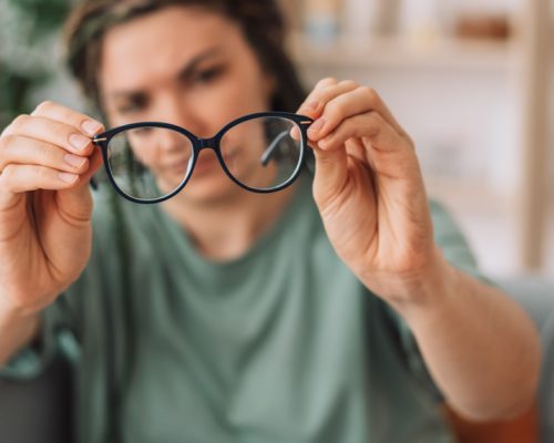 The girl looks at the glasses checking for dirt.